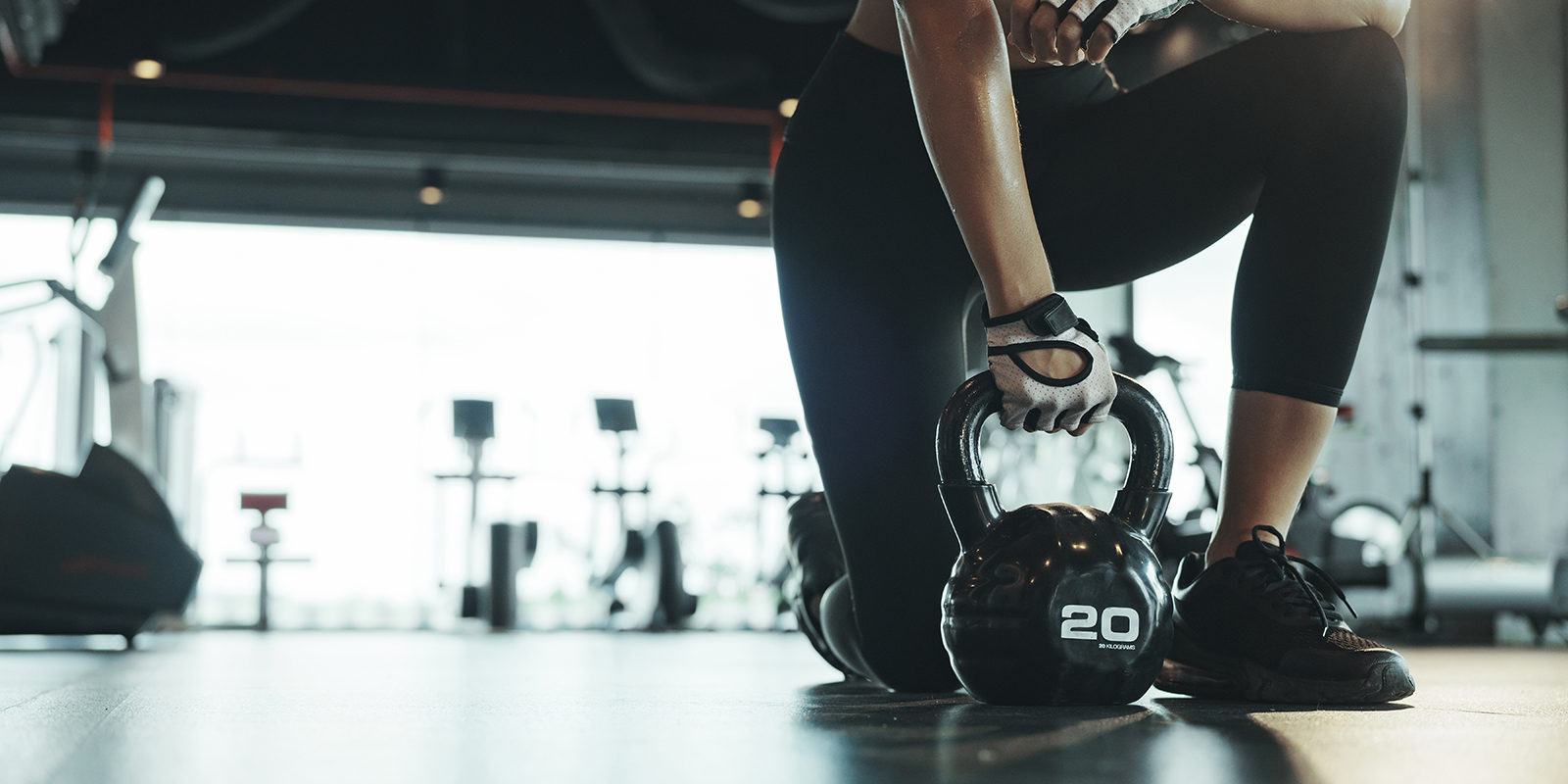 Woman picking up kettlebell to put it away